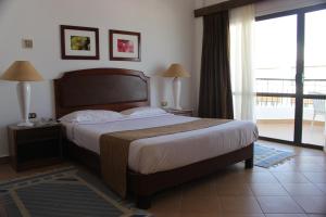 a bedroom with a large bed and a balcony at Marlin Inn Azur Resort in Hurghada