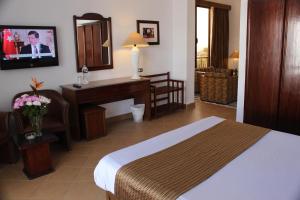 Habitación de hotel con cama, escritorio y ordenador en Marlin Inn Azur Resort en Hurghada