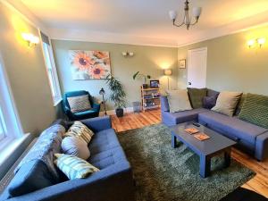 uma sala de estar com sofás azuis e uma mesa em The Hideaway - Central Townhouse em Wareham