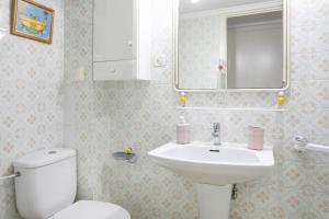 a bathroom with a sink and a toilet and a mirror at Sunflower Pasaje in Santa Pola +11 photos