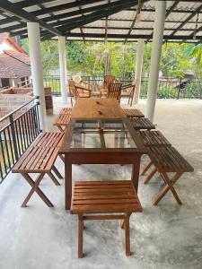 een houten tafel en stoelen op een patio bij Cozy Resort in Matara