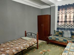 een slaapkamer met 2 bedden, een kast en een raam bij Appartement F3 équipé, spacieux près du centre in Biskra