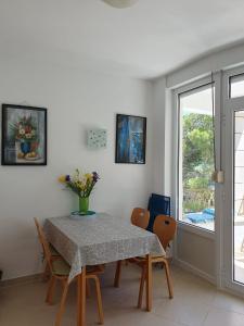 a dining room with a table and chairs and a window at Inas Place in Baška Voda