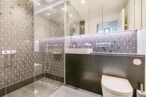 a bathroom with a toilet and a glass shower at Royal Luxury 3 Beds: Central Covent Garden Haven in London