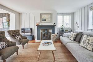 a living room with a couch and a fireplace at Filbert cottage, log fire and tennis court in Rolvenden
