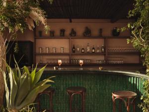 a bar with stools and wine glasses in a restaurant at IZZA Marrakech in Marrakesh