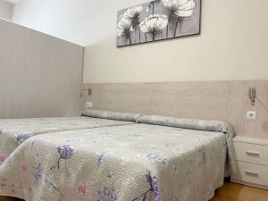 Un dormitorio con una cama y un cuadro en la pared. en Apartamentos Turisticos Mediterraneo, en Cartagena