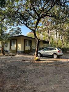 a car parked in front of a house with a tree at Mhaske Farms in Pune