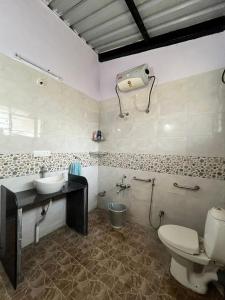 a bathroom with a sink and a toilet in it at Mhaske Farms in Pune