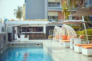 a swimming pool with tables and chairs next to a building at Maison Fahrenheit in Lagos