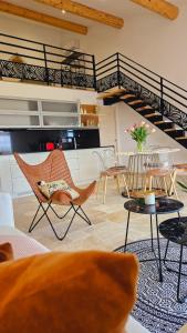 een woonkamer met stoelen en een wenteltrap bij Pissenlit Une Prairie en Provence in Arles