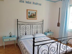 1 dormitorio con 1 cama y 2 mesas azules en Locanda D'Ogliastra,, en Triei