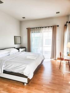 a bedroom with a large bed and a large window at Simple & Cozy Home in prime location. Chiang Mai in Chiang Mai