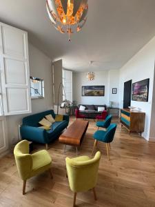 a living room with a blue couch and chairs at L'annexe Bordeaux Traditions in Bordeaux