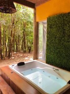 a bath tub sitting in front of a window at Prime Villas do pratagy in Maceió