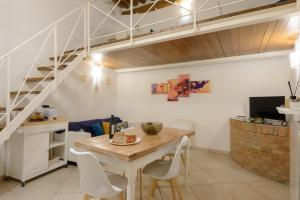 a dining room with a table and a staircase at Casa Vezzosa in Siena