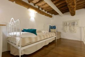 a bedroom with a white bed with blue pillows at Casa Vezzosa in Siena