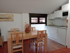 a kitchen with a wooden table and chairs in a kitchen at Apartamentos La Piedra de Nájera in Nájera