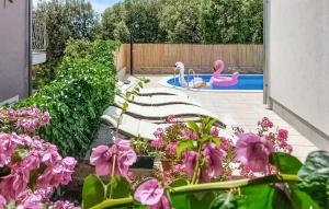 un jardin avec des fleurs roses et une piscine avec des cygnes dans l'établissement Stunning Apartment In Brodarica, à Brodarica