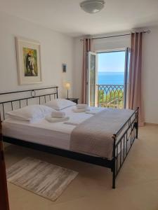 a bedroom with a bed with a view of the ocean at Inas Place in Baška Voda