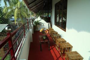 una fila de mesas y sillas en un balcón en DreamCatcher Residency, en Kochi