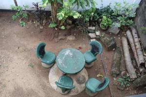 a green table and chairs on the ground at ගයාන් ගෙස්ට් කතරගම in Kataragama