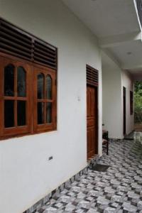 a white building with a door and a tile floor at ගයාන් ගෙස්ට් කතරගම in Kataragama