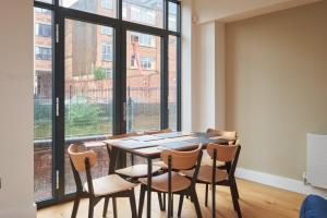 a dining room with a table and chairs and a large window at GuestReady - Delightful stay near the city centre in Birmingham