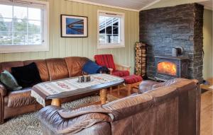 a living room with leather furniture and a fireplace at Nice Home In Fossdal With House A Panoramic View in Fossdal