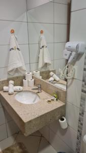 a bathroom counter with a sink and a mirror at Apartamento 1411 Barretos Park Hotel - O Hotel do Parque do Peão in Barretos