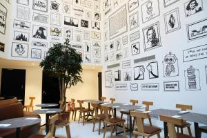 une salle à manger avec des tables et des chaises et un mur de photos dans l'établissement SO City Hotel Adults Only, à San Ġiljan