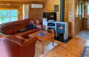 a living room with a leather couch and a fireplace at Amazing Home In Fllinge With Wifi in Vallrun