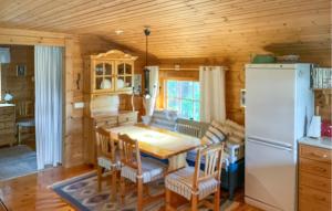 a kitchen with a table and a refrigerator at Amazing Home In Fllinge With Wifi in Vallrun