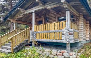 a log cabin with a wooden porch and stairs at Beautiful Home In Fllinge With 1 Bedrooms in Vallrun