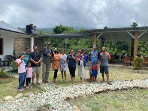 una familia posando para una foto frente a una casa en Rago's Homestay, en Kelimutu