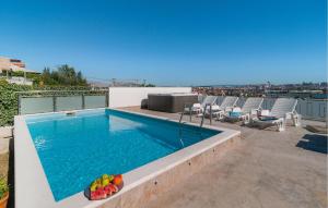 a swimming pool on the roof of a building with chairs at Cozy Apartment In Solin With Kitchen in Solin