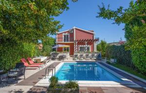 a swimming pool in front of a house at Lovely Home In Trilj With Heated Swimming Pool in Trilj