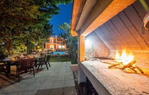 a fire pit on a patio with a table and chairs at Lovely Home In Trilj With Heated Swimming Pool in Trilj