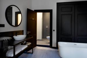 La salle de bains est pourvue d'une baignoire, d'un lavabo et d'un miroir. dans l'établissement Catalonia Vondel Amsterdam, à Amsterdam