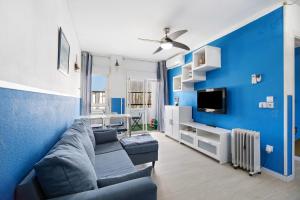 sala de estar con sofá y pared azul en El Marinero, en Rota