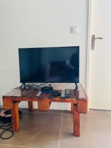 einen Holztisch mit einem TV darüber in der Unterkunft Twin House #2 in Ponta do Ouro