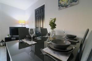 a dining room with a black table with plates and wine glasses at Signature - Sunnyside House in Holytown