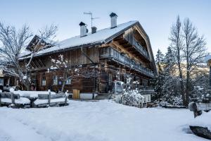 a large log cabin with snow on the ground at Lechnerhof Apt 1 in Braies