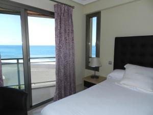 Una habitación con cama y vistas al océano. en Balcón del Puerto, Ático-Solarium, en Tazacorte 42 fotos más