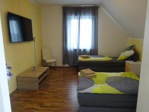sala de estar con 2 camas y TV en Private Ferienwohnung Lan en Bad Rothenfelde