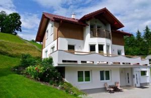 a large white house with a balcony on a hill at Appartement Heidi in Schladming