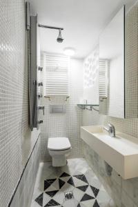 a white bathroom with a sink and a toilet at Charming Cozy Lavapies in Madrid