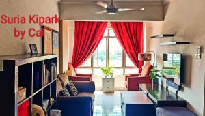 uma sala de estar com sofás e uma janela com cortinas vermelhas em Suria Kipark Damansara 750sq ft Studio Apartment em Kepong