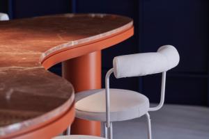 a white stool next to a wooden table at The Newel Acropolis in Athens