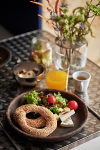 a plate of food with a pretzel and vegetables on a table at The Newel Acropolis in Athens